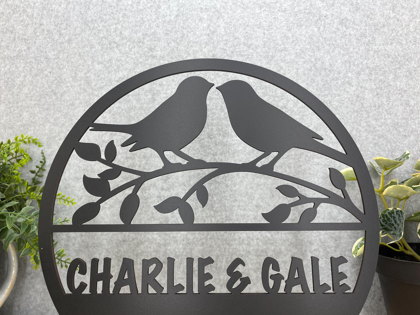 a couple of birds sitting on top of a metal sign