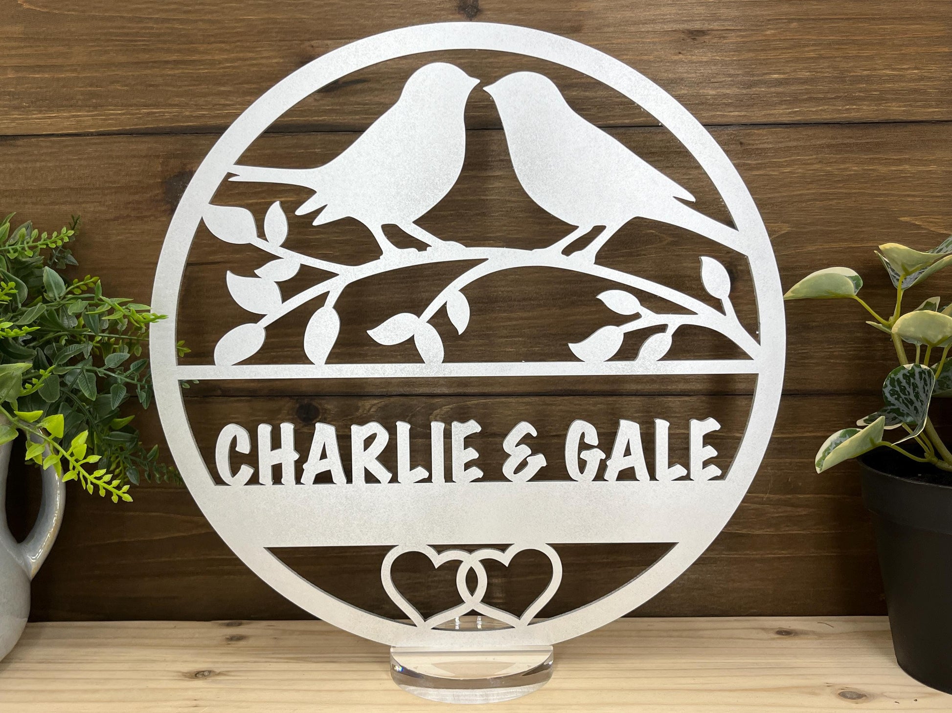 a couple of birds sitting on top of a metal sign
