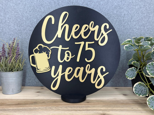 a sign that says cheers to 75 years next to potted plants