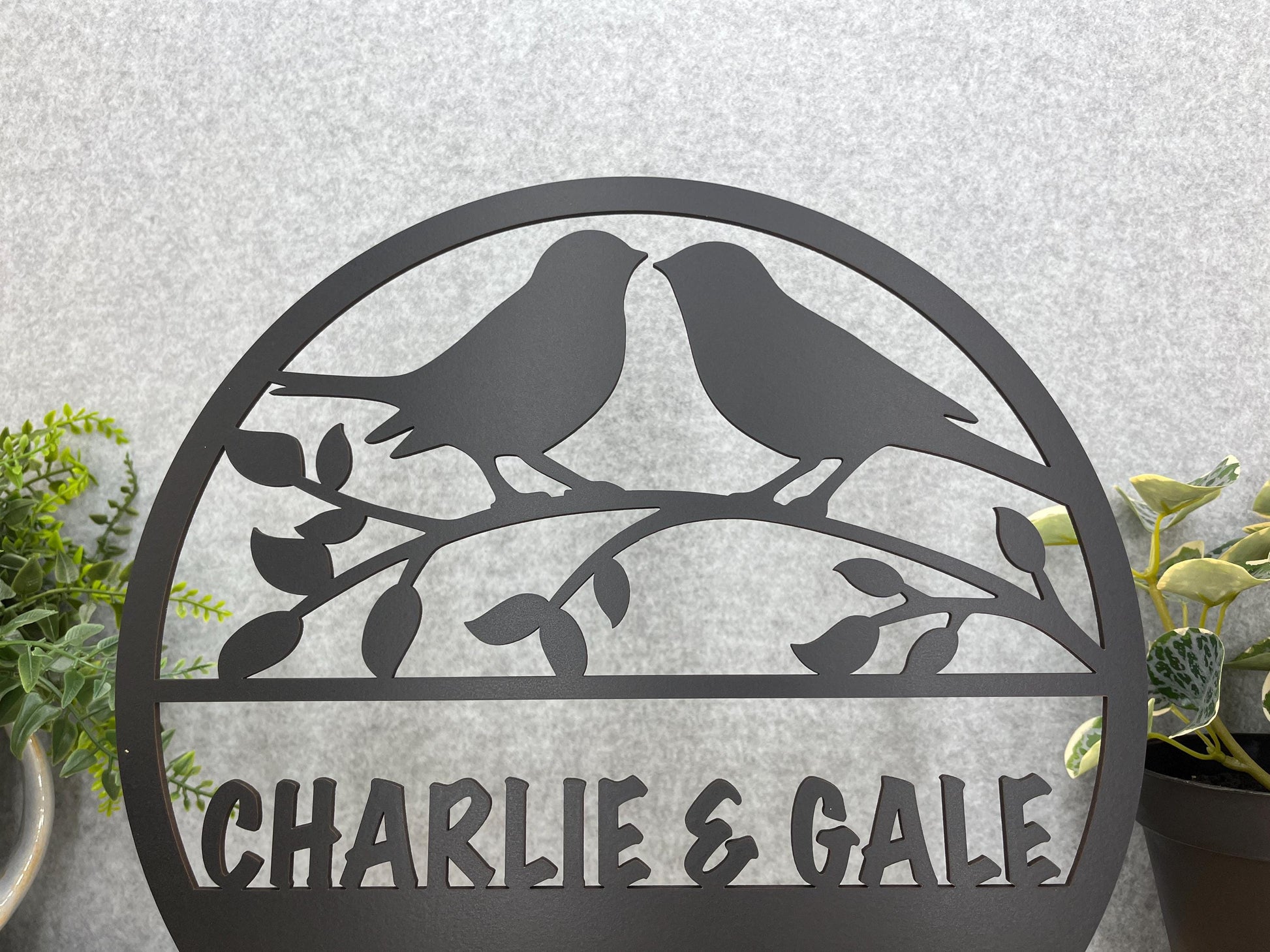 a couple of birds sitting on top of a metal sign