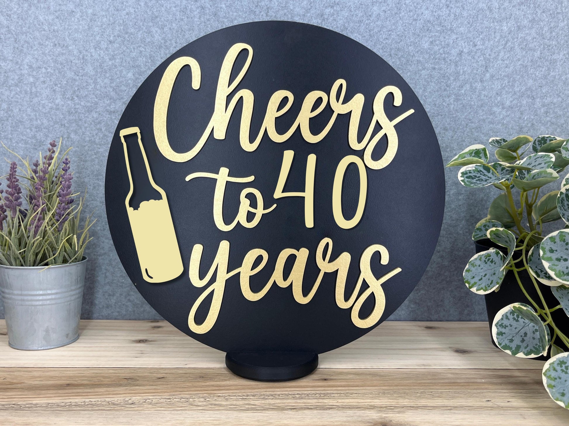 a sign that says cheers to 40 years next to potted plants