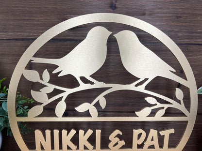 a metal sign with two birds sitting on a branch