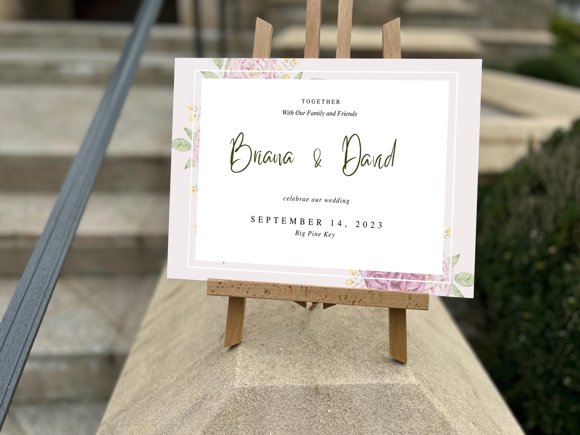 a wooden easel holding a sign with a floral design
