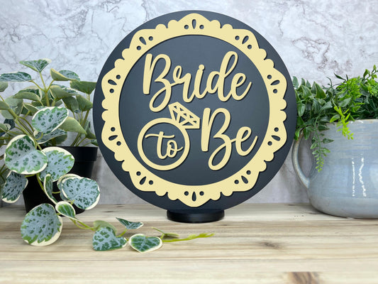 a bride to be sign next to a potted plant