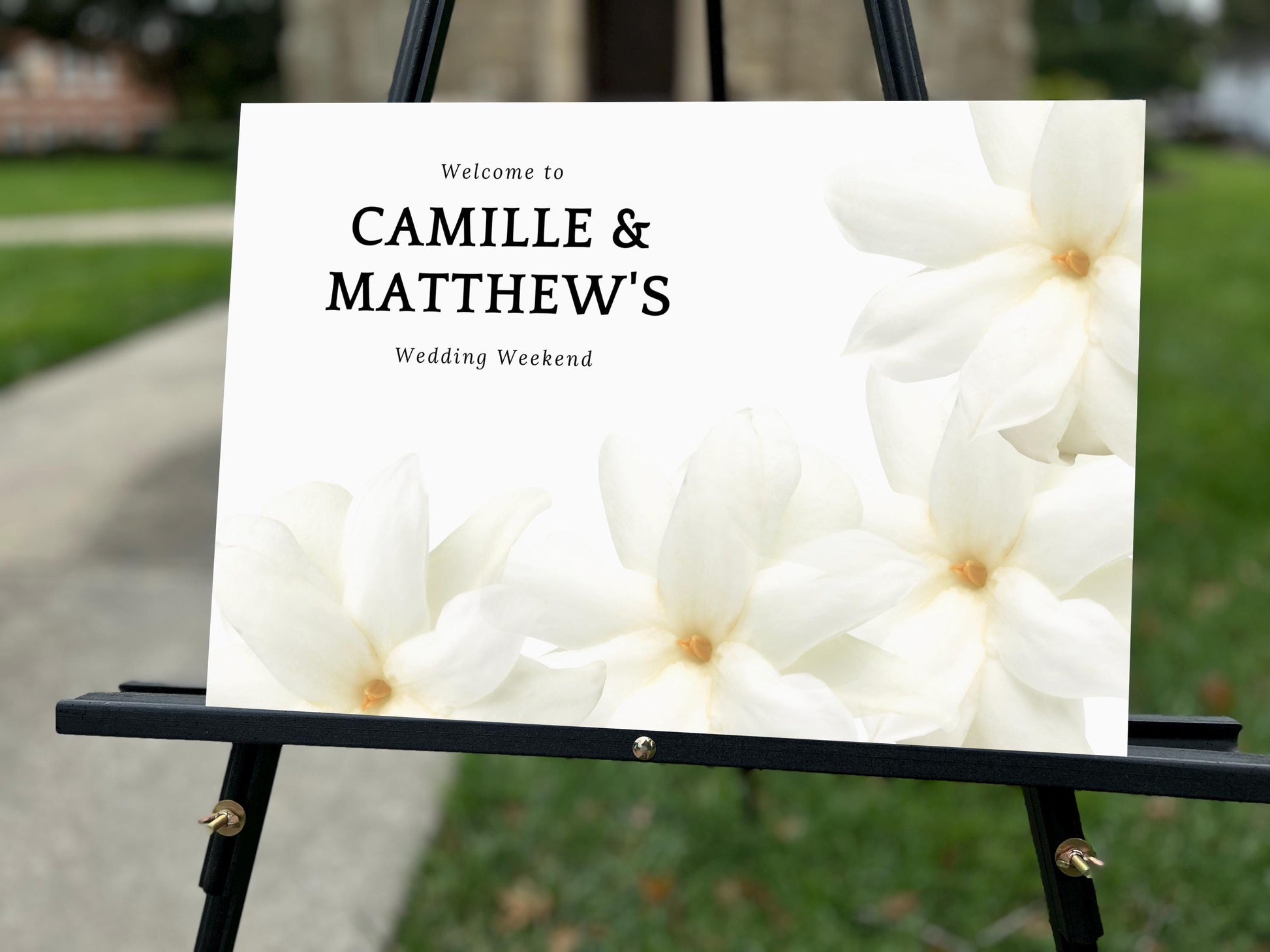 a welcome sign with white flowers on it