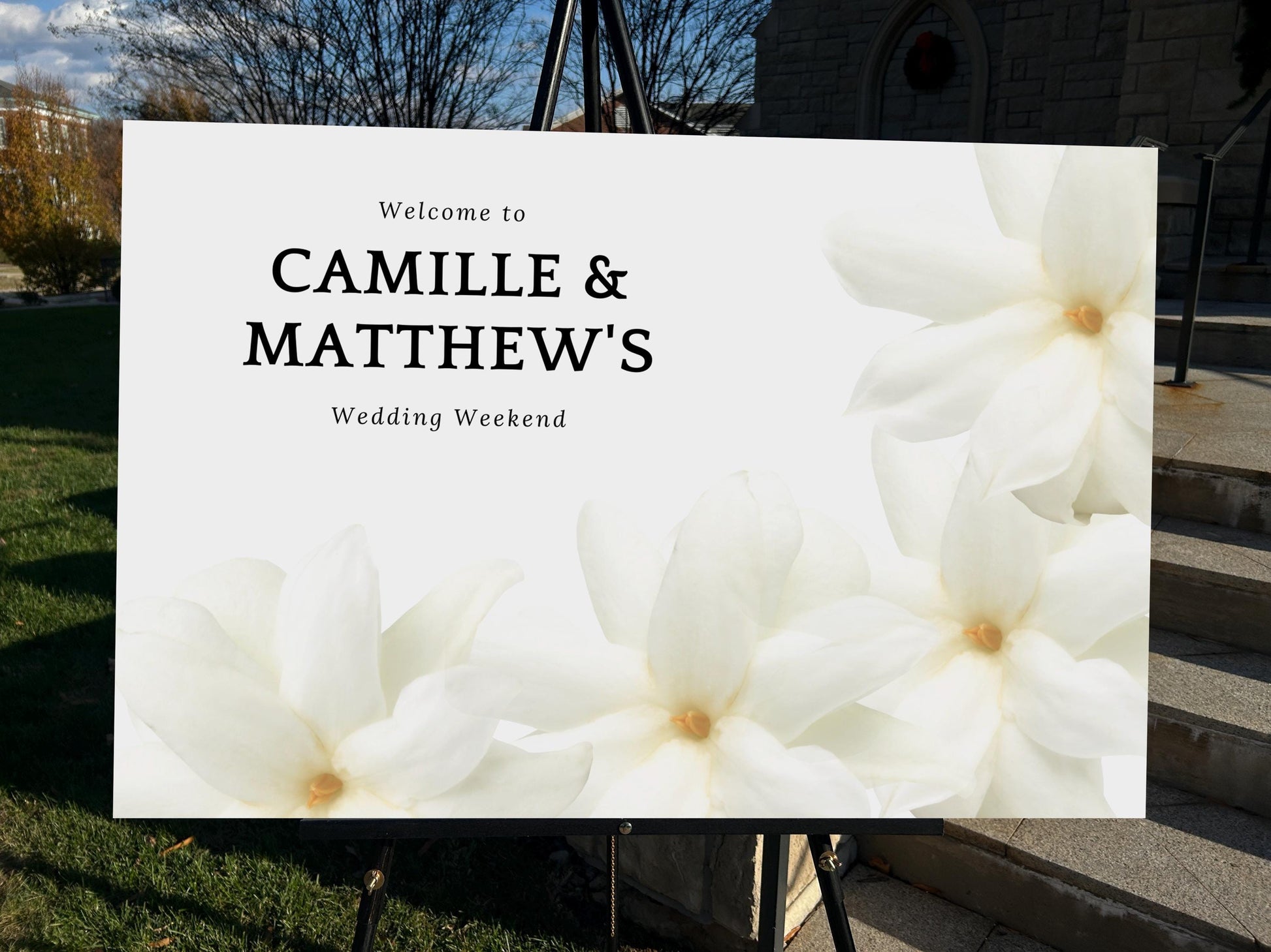 a welcome sign for a wedding with white flowers