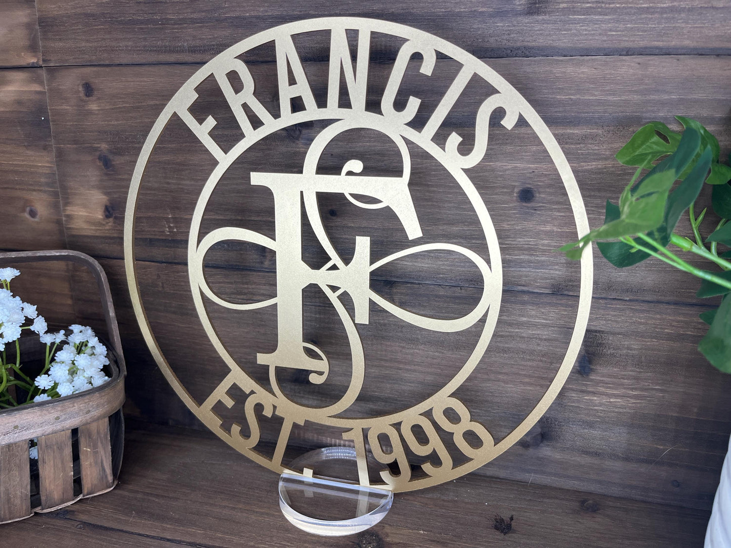 a metal sign on a wooden wall next to a potted plant