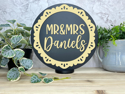 a black and gold mr and mrs sign next to a potted plant